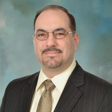 a man wearing glasses and a suit
