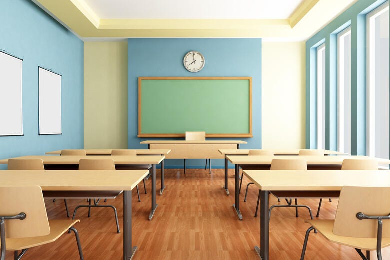 a classroom with desks and a large screen