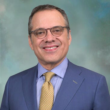 a man wearing glasses and a suit