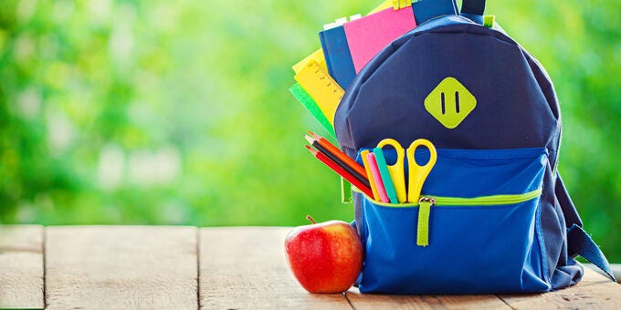 a bag with a bag and a red apple on a wood surface